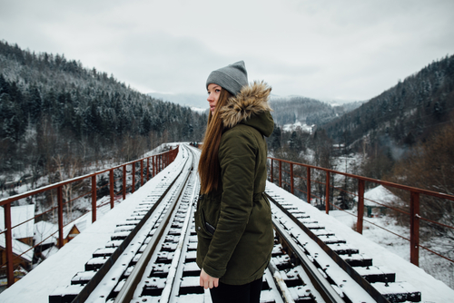 Girl in fleece jacket on railway bridge in winter day