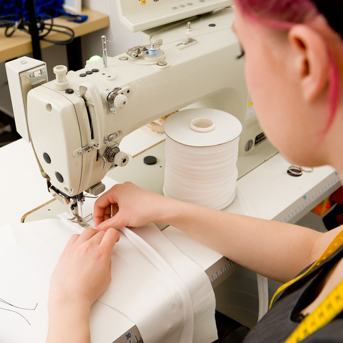 Worker sewing shirts