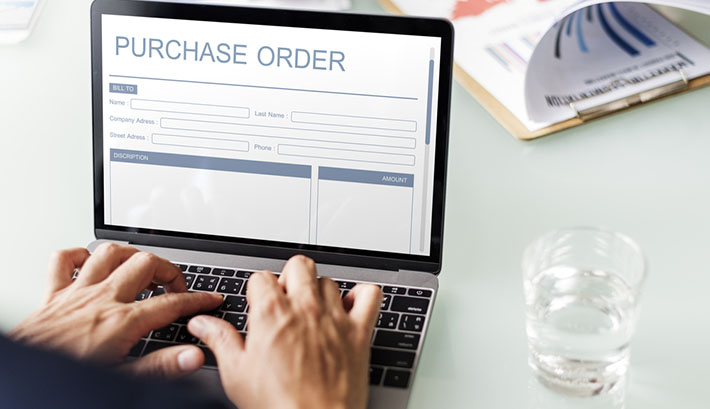 man on laptop using purchase order form