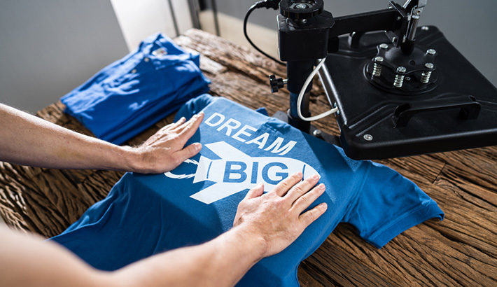 Man Printing On T Shirt In Workshop