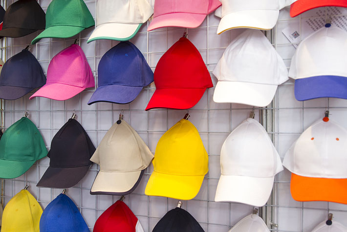 baseball caps hanging on vendor wall